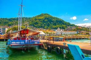 a boat is docked at a dock in the water at valenshostel in Angra dos Reis