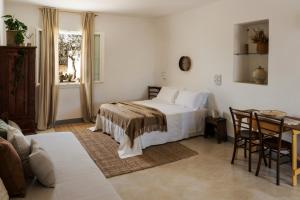 Schlafzimmer mit einem Bett, einem Tisch und Stühlen in der Unterkunft Sikalindi Apulian Farm&Living in Gagliano del Capo