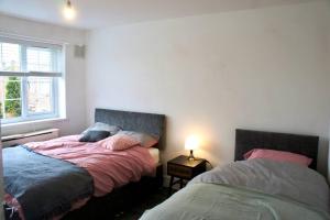 een slaapkamer met 2 bedden naast een raam bij Swinton, Manchester in Manchester