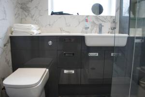 a bathroom with a sink and a toilet and a mirror at Swinton, Manchester in Manchester