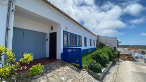 una casa azul y blanca con una puerta azul en Apartamento Miradouro, en Carrapateira