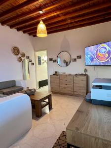 a living room with a couch and a tv at Lux Mykonos house in Agios Stefanos