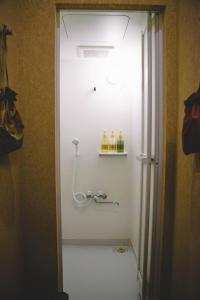 baño con ducha con pared blanca en WASEIDOU ZEN - Vacation STAY 17230v en Kobe