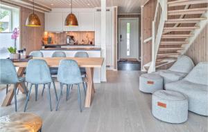 FærvikにあるAmazing Home In Frvik With Wifiのキッチン、ダイニングルーム(木製のテーブルと椅子付)