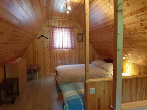 a bedroom with a bed in a wooden cabin at Cottage Lepena in Soča