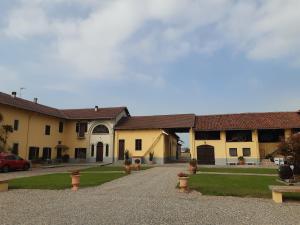 a large yellow building with a driveway at Tenuta Aranuova in Vercelli