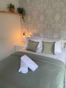 a bedroom with a bed with two pillows on it at The Garden room in Honiton