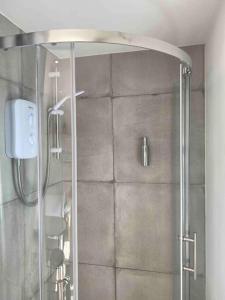a shower with a glass door in a bathroom at The Garden room in Honiton