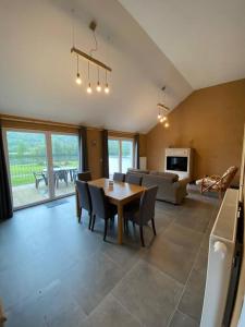 a living room with a table and chairs and a couch at Le Pré sous l'eau - NATURA in Anhée