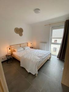 a bedroom with a large bed and a window at Le Pré sous l'eau - NATURA in Anhée +13 photos