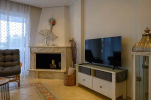 een woonkamer met een flatscreen-tv en een open haard bij Marine Luxury Apartment Kalamata in Kalamata
