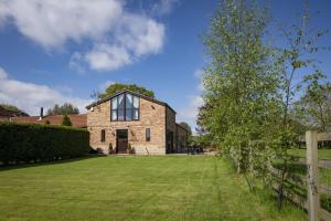 a large brick house with a large yard at Tockwith Lodge Barn in York