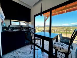 a kitchen with a table and chairs with a view at Colibrí Tiny House in Valle de Guadalupe