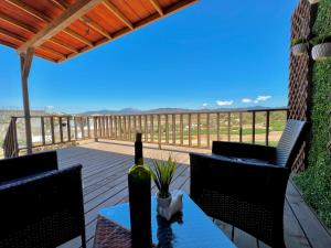 una botella de vino sentada en una mesa en una terraza en Colibrí Tiny House en Valle de Guadalupe