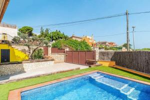 a swimming pool in the backyard of a house at Casa rustica con piscina y jardin in Pineda de Mar