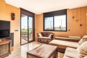 a living room with a couch and a tv at Casa rustica con piscina y jardin in Pineda de Mar