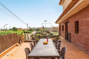 Une table et des chaises en bois sont disponibles sur la terrasse. dans l'établissement Casa rustica con piscina y jardin, à Pineda de Mar