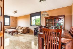 Una cocina y una sala de estar con un sofá y una mesa. en Casa rustica con piscina y jardin, en Pineda de Mar