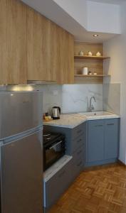 cocina con armarios azules, fregadero y nevera en Διαμέρισμα σε πολυκατοικία en Serres