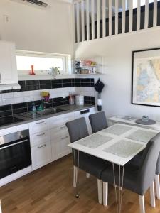 Mycket trevlig stuga på Brännö med havsutsikt في Brännö: مطبخ مع طاولة وكراسي في غرفة