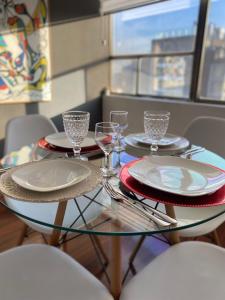 una mesa de cristal con platos y copas de vino. en Departamento en Providencia, en Santiago