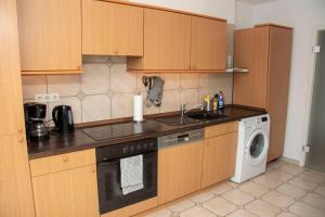a kitchen with a sink and a washing machine at Apartment am Kurpark in Bad Segeberg +4 photos