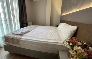 a bedroom with a bed with a vase of flowers at Niconya Port Suite&Hotel in Istanbul
