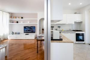 uma cozinha com armários brancos e piso em madeira em Casa mia a Nervi em Gênova