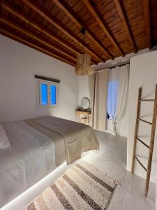 a bedroom with a large bed with a wooden ceiling at Lux Mykonos house in Agios Stefanos