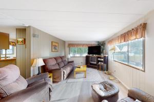 a living room with two couches and a tv at Lazy Dayz Cottage in Christina