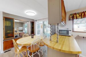 a kitchen and dining room with a wooden table and chairs at Lazy Dayz Cottage in Christina