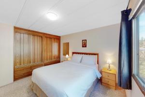 a bedroom with a large white bed and a window at Lazy Dayz Cottage in Christina +19 photos