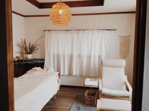 HiokiI&I hostel (旅宿酒場 アヤナイ)的一间卧室，里面有一张床、一把椅子和一扇窗户