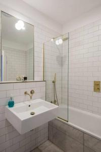 biała łazienka z umywalką i prysznicem w obiekcie Jane's View - Luxury apartment with breathtaking views w mieście Kent