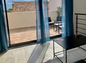 een kamer met uitzicht op een balkon met een tafel bij Rooftop Agde in Agde
