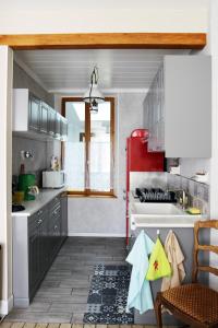 uma cozinha com um fogão branco e um frigorífico vermelho em Le gîte embarqué - Géré par Presta-Zen'Services - Barque électrique en supplément em Verdun-sur-Meuse