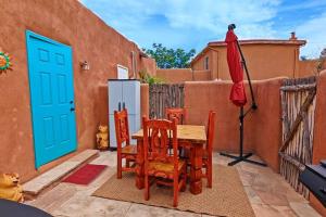 een patio met een tafel en stoelen en een koelkast bij Magical Santa Fe Stay, Minutes From Town Square, Sleeps 4, includes free parking and outdoor hot tub! in Santa Fe