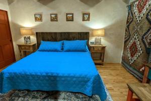 een slaapkamer met een blauw bed en 2 nachtkastjes bij Magical Santa Fe Stay, Minutes From Town Square, Sleeps 4, includes free parking and outdoor hot tub! in Santa Fe