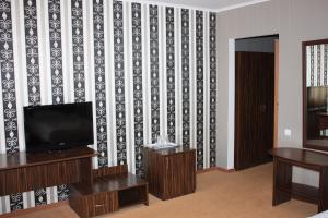 a living room with a tv and a wall at Europa Hotel in Chişinău