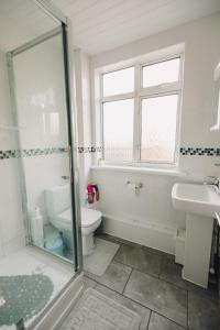 een badkamer met een toilet, een wastafel en een douche bij Luxury Central Luton - King-size Apartment - Free Parking - Free Wi-Fi - Near Shops & LTN Airport in Luton