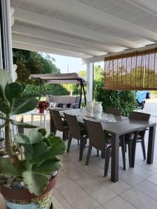 une table et des chaises sur une terrasse avec une table dans l'établissement Casa vacanze tizy, à Raguse