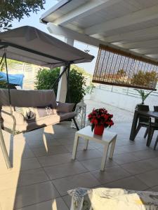 - une terrasse avec un parasol et une table fleurie dans l'établissement Casa vacanze tizy, à Raguse