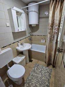 a bathroom with a toilet and a sink and a tub at Duca apartmani in Šabac