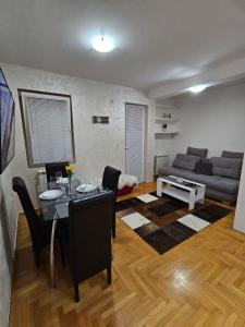 ein Wohnzimmer mit einem Tisch und einem Sofa in der Unterkunft Duca apartmani in Šabac