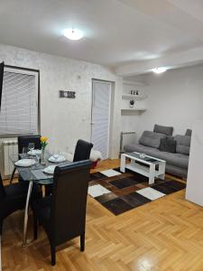 een woonkamer met een tafel en een bank bij Duca apartmani in Šabac