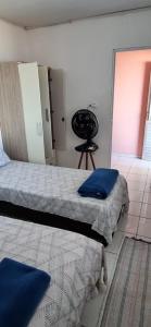 a bedroom with two beds with blue pillows at Quartos privativo frente mar com banheiro compartilhado in Maragogi