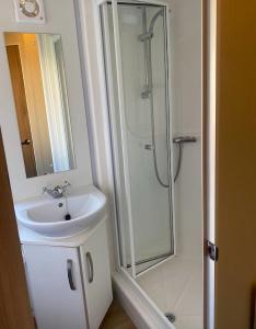 uma casa de banho com um lavatório e um chuveiro em Beach Caravan Holiday Home em Mablethorpe