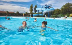 a group of people swimming in a swimming pool at Beach Caravan Holiday Home in Mablethorpe