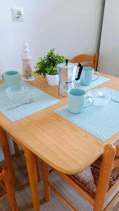 un tavolo in legno con tazze e piatti blu sopra di Acogedor y luminoso piso Santander a Santander