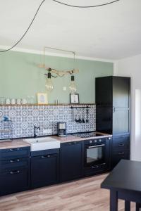 a kitchen with dark blue cabinets and a sink at Meerblick und Salz in der Luft in Fehmarn